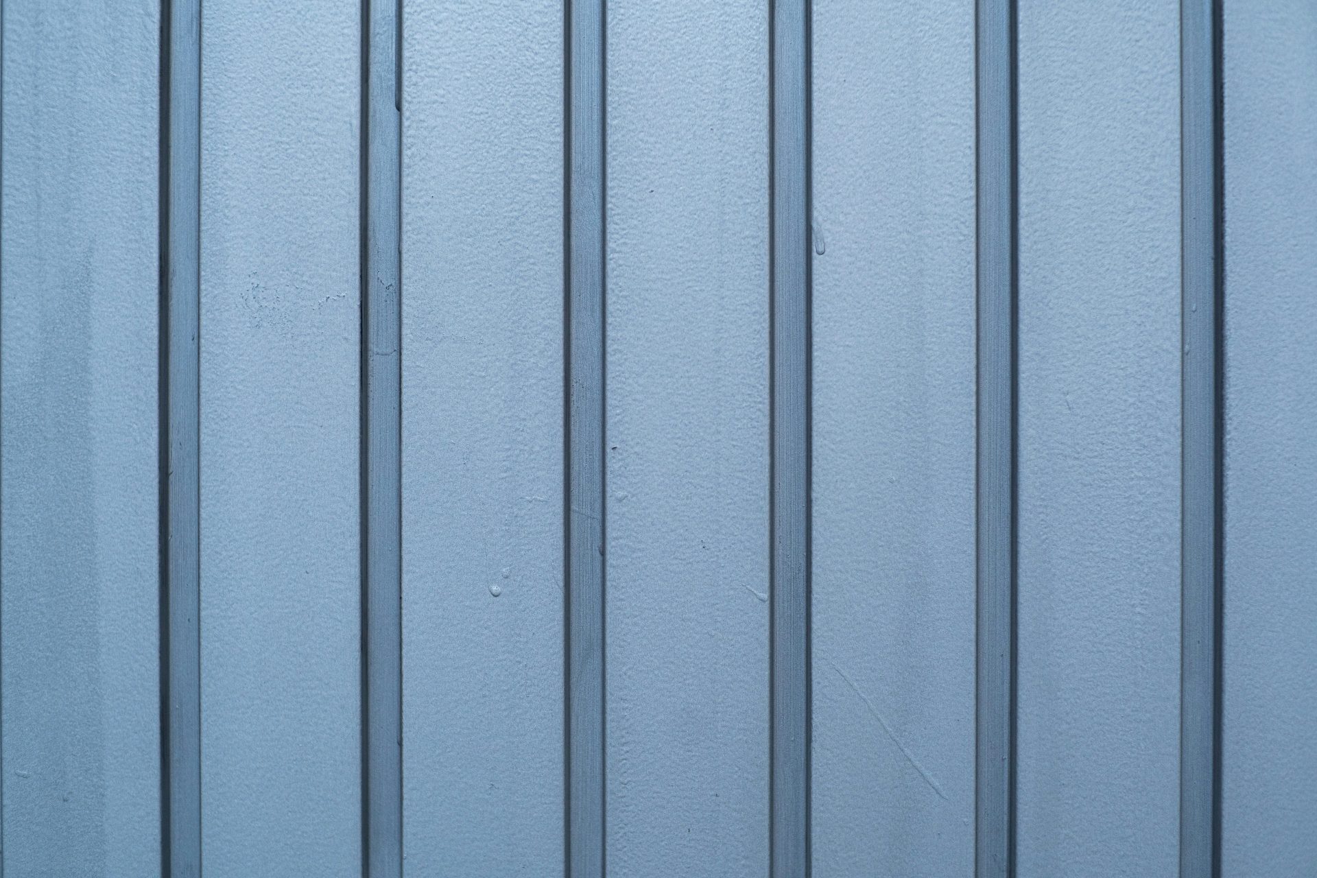 a close up of a blue metal wall